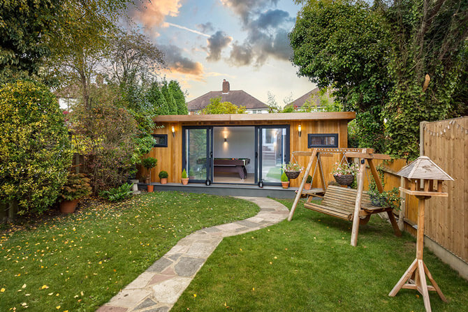 garden games room with open sliding doors & a pool table inside